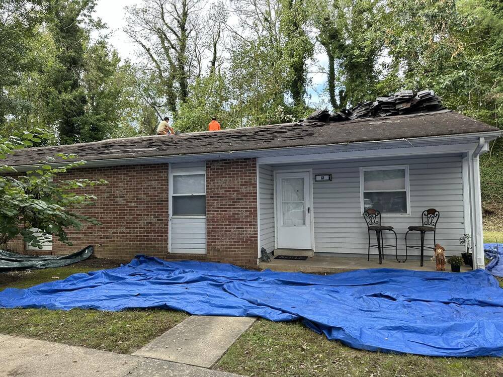 Crews working on a house roof top.